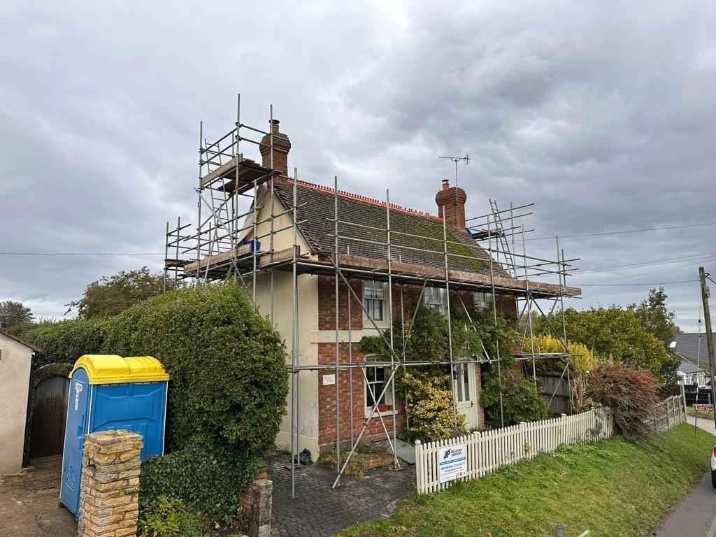 A re-roofing project underway on a scaffolded house by J P Building Services