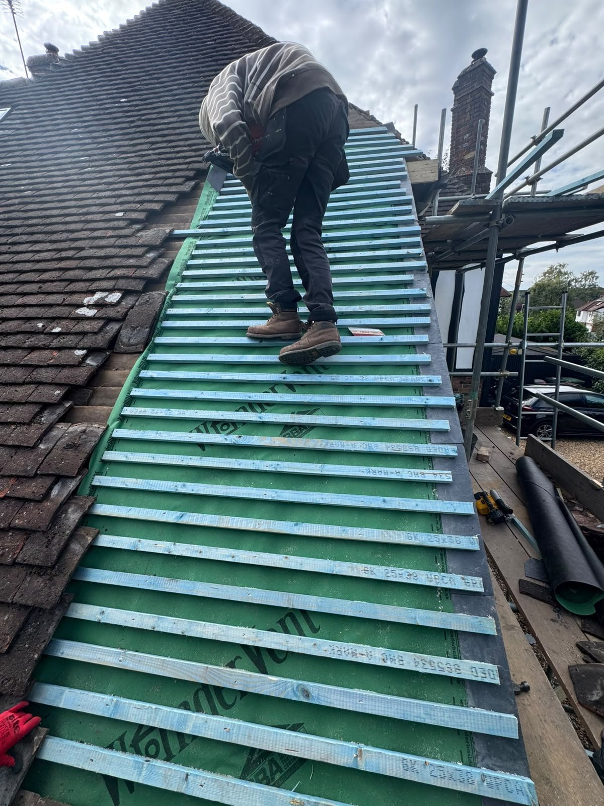 A roofer fitting new roofing membrane for J P Building Services